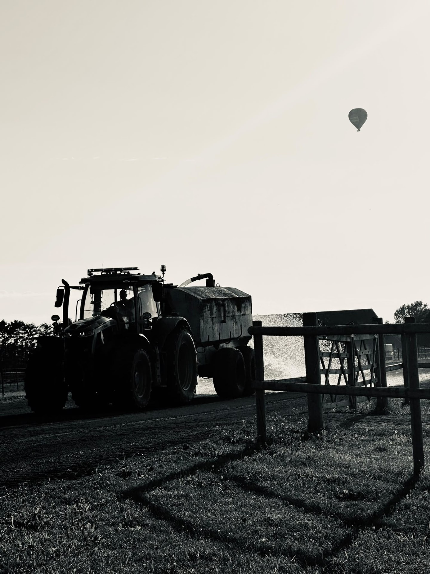 Traktor på gården i svartvitt med luftballong på himlen