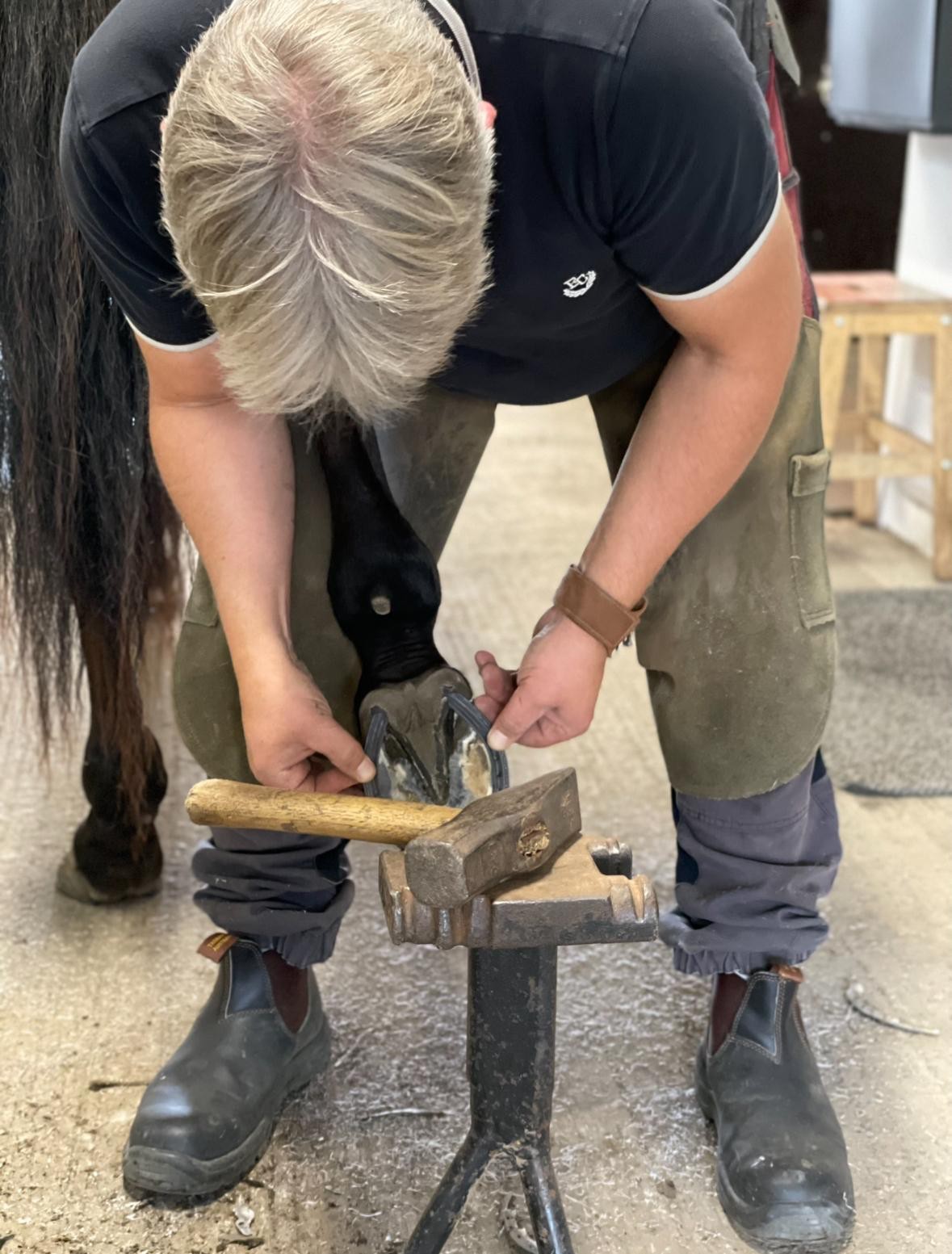 Hovslagare i arbete i stallet