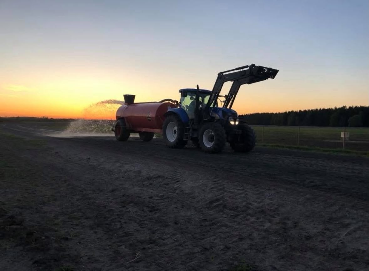 Traktor vattnar banan i solnedgång